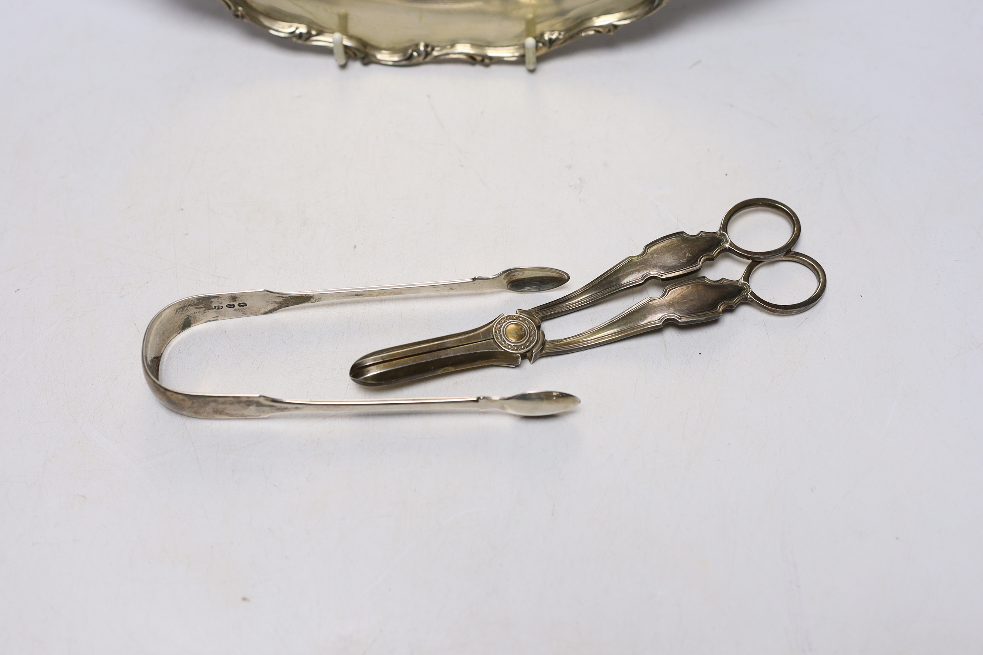 A 20th century Mexican 925 sterling circular platter, 30.1cm, a pair of Georgian silver sugar tongs and a later pair of silver grape shears, 26oz.